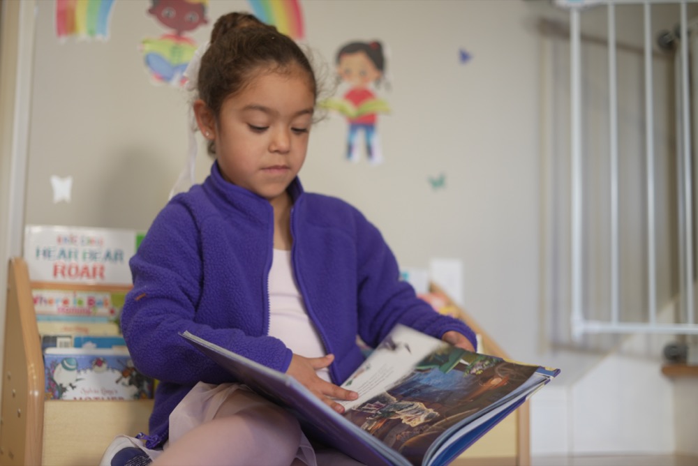 Caregiver reading a bedtime story at Little Explorers